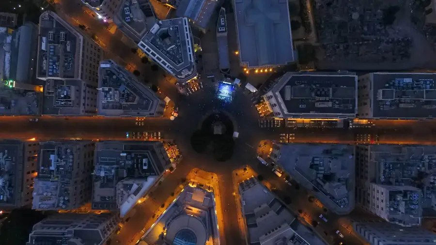 Aerial night view of a city roundabout with radiating streets