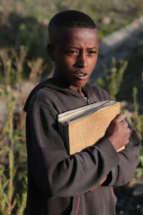 Portrait of a boy holding a school book in the highlands
