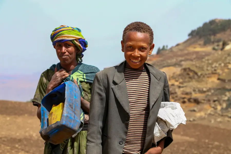 Mother and son smiling on a dry mountain slope, documentary portrait