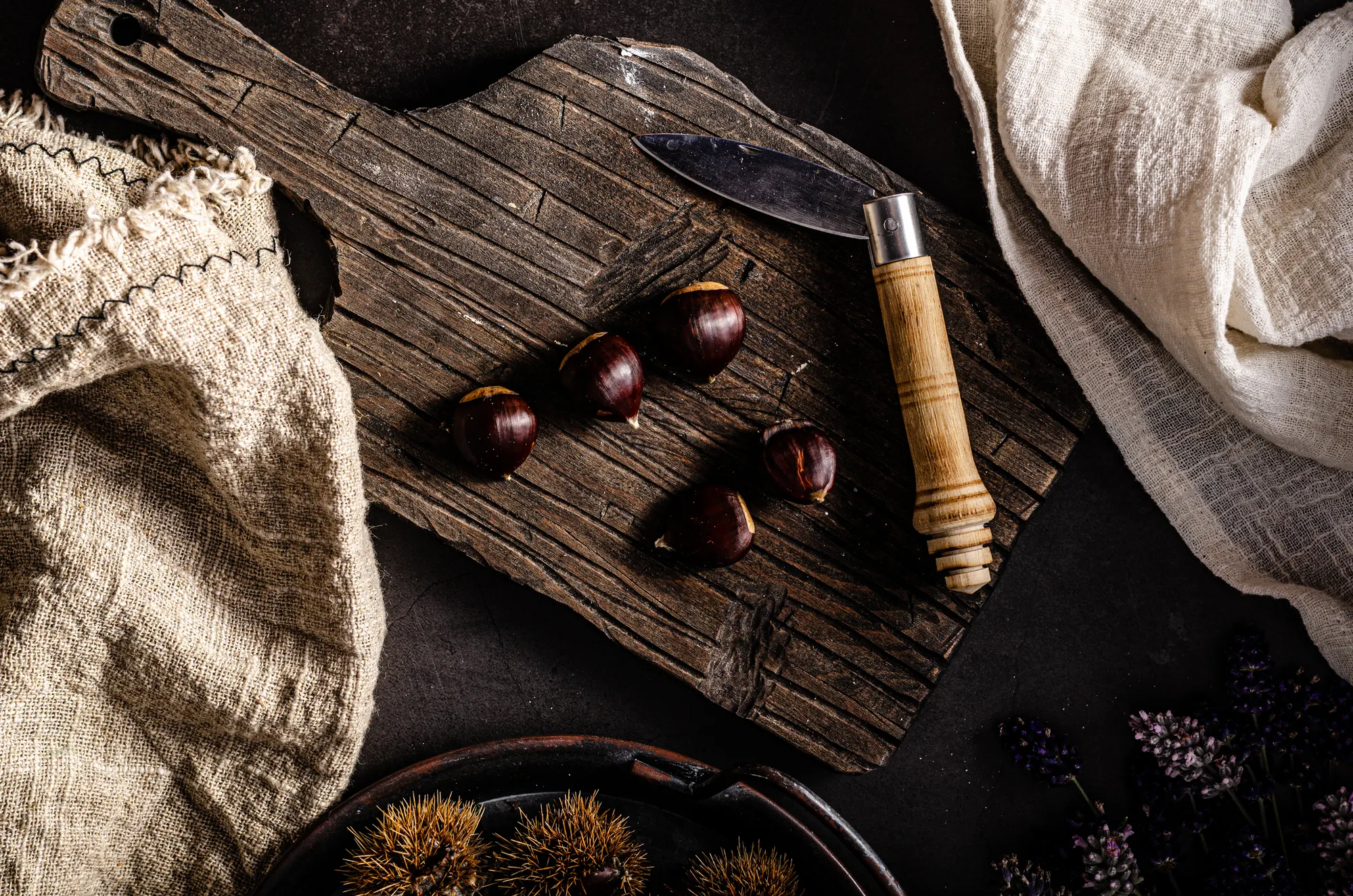 Roasted chestnuts on a rustic board, moody food styling