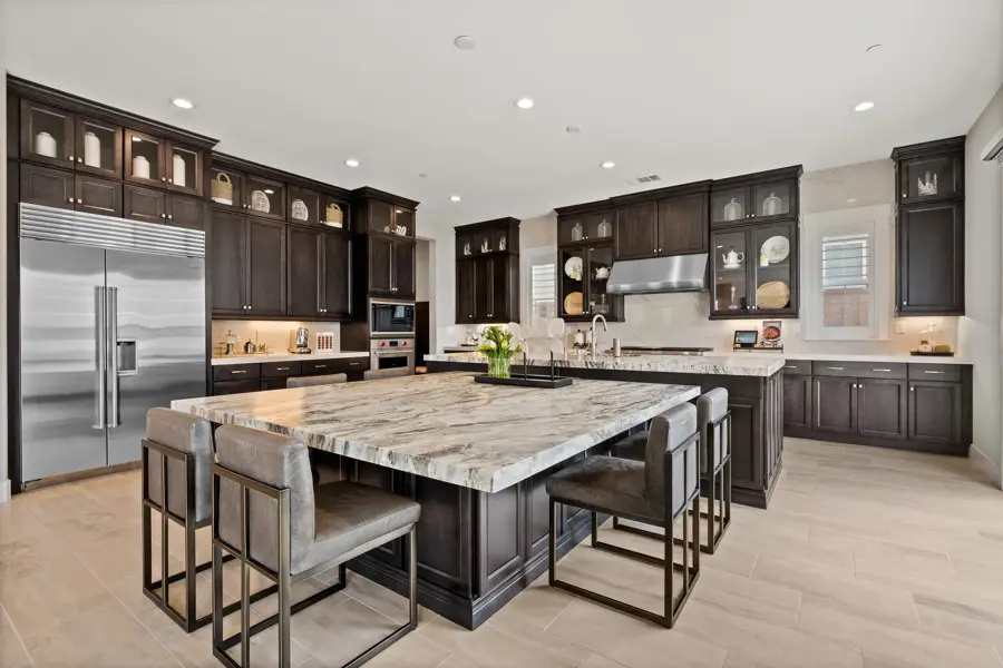 Luxury kitchen with a large marble island and dark cabinets