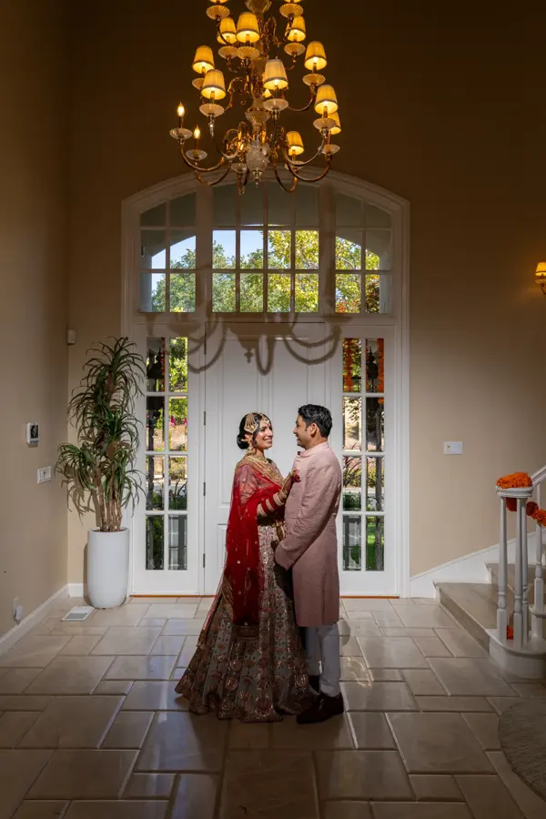 Indian bride and groom in traditional attire in an elegant entry hall